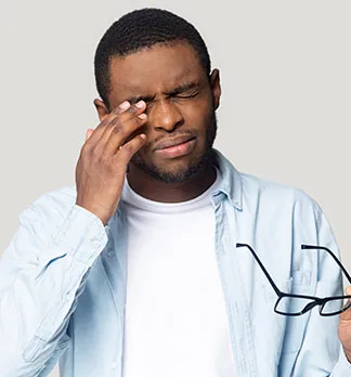 Black man rubbing eye